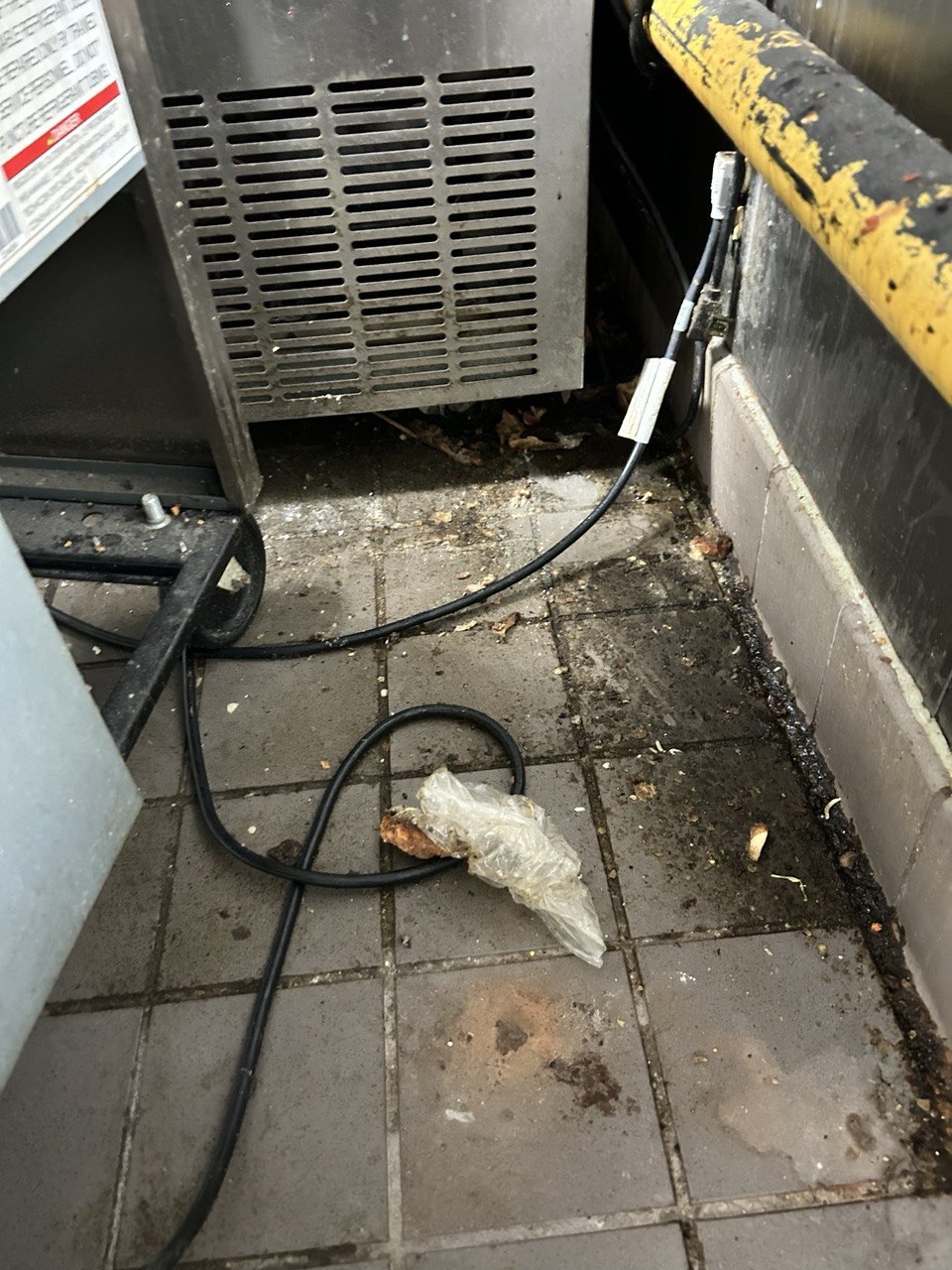 Kitchen equipment corner before cleaning — built-up grease and debris